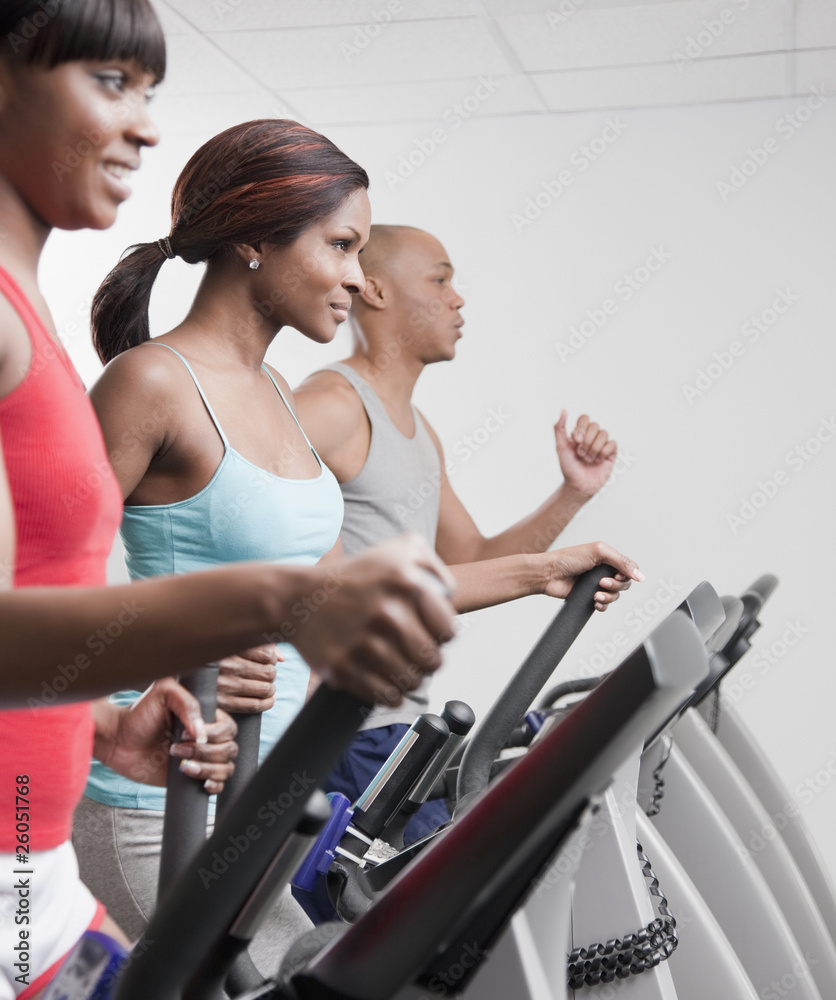 African people using exercise equipment in health club African people using exercise equipment in health club