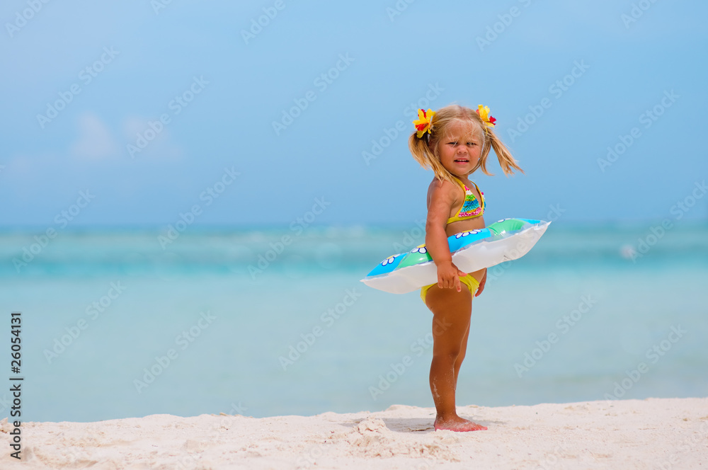 Toddler cute girl with Inflatable circle on tropical beach Toddler cute girl with Inflatable circle on tropical beach