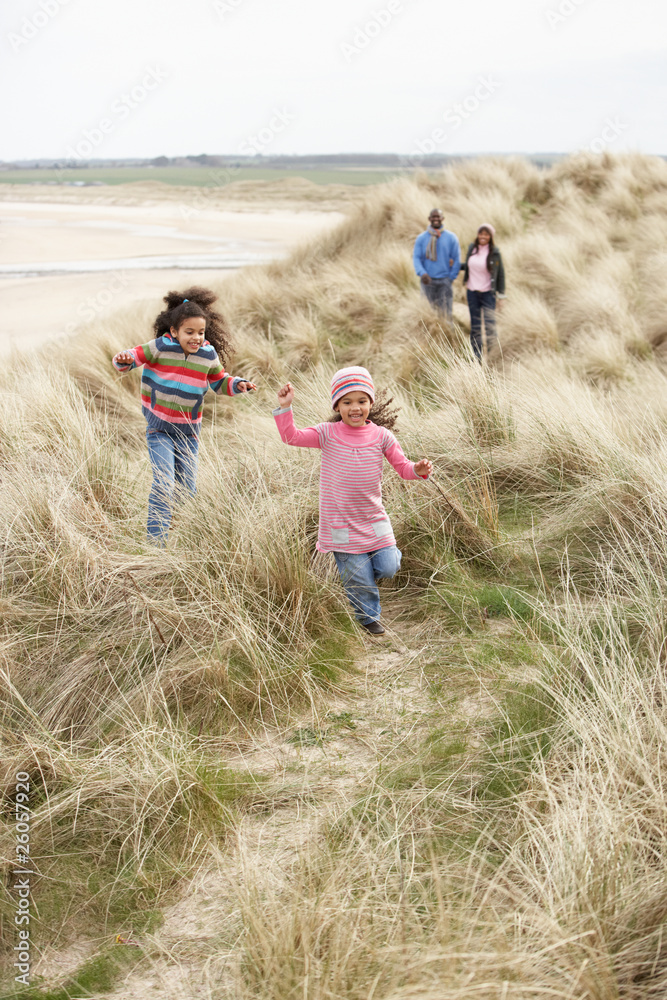 Family Walking Along Dunes On Winter Beach Family Walking Along Dunes On Winter Beach