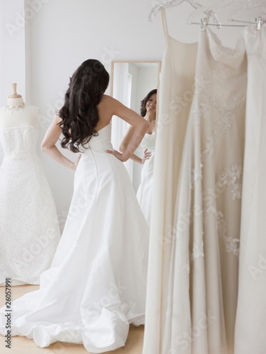 Mixed race woman trying on wedding dresses
