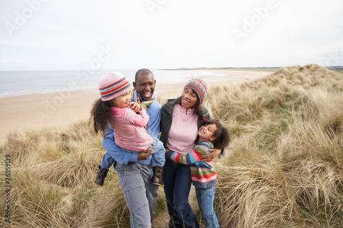 Family Walking Along Dunes On Winter Beach © micromonkey
