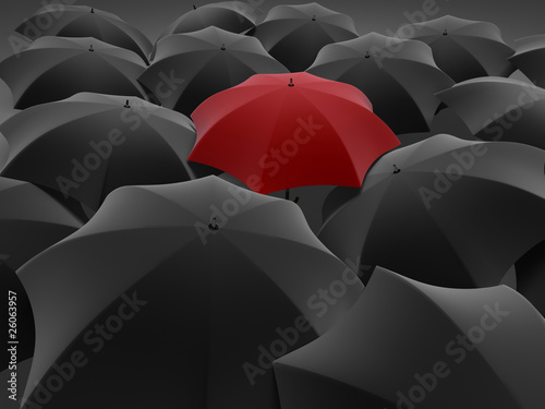 One red umbrella among set of other black photo