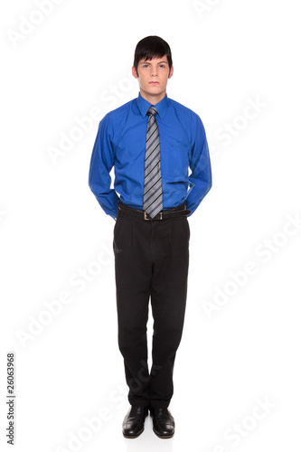 businessman standing with hands clasped behind his back