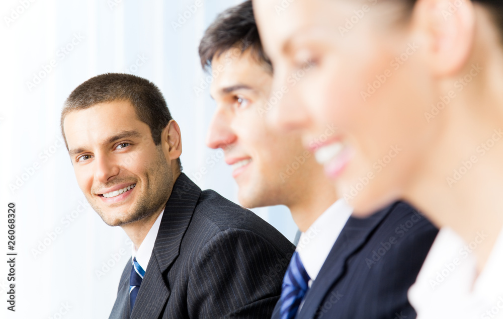 Three successful businesspeople at office, focus on man Three successful businesspeople at office, focus on man