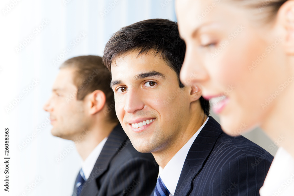 Three successful businesspeople at office, focus on man Three successful businesspeople at office, focus on man