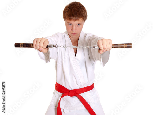 Teenage in kimono making exercise with nunchuck