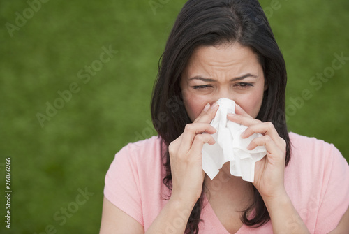 Hispanic woman blowing nose
