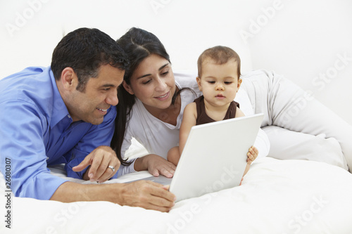 Hispanic family looking at laptop photo