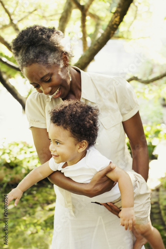 African woman playing with son outdoors photo