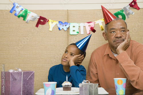 African boy with grandfather and cupcake at birthday party photo