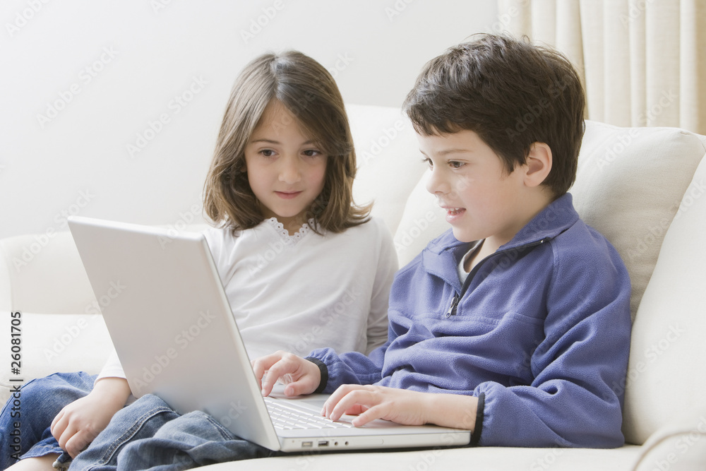 Hispanic brother and sister using laptop Hispanic brother and sister using laptop
