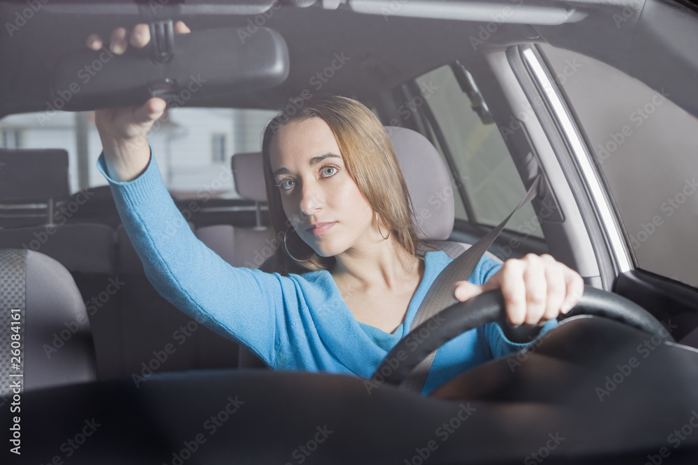 Hispanic woman adjusting rearview mirror Hispanic woman adjusting rearview mirror