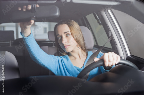Hispanic woman adjusting rearview mirror photo