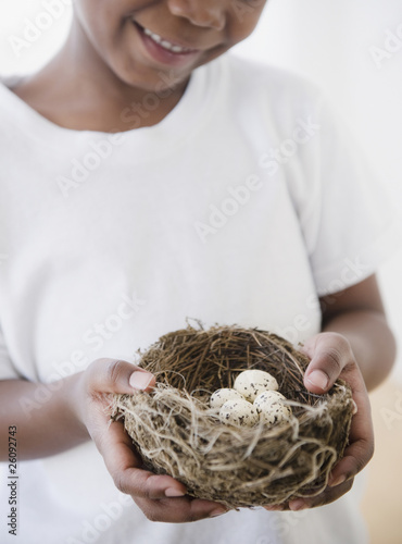 Black boy holding nest with bird’s eggs