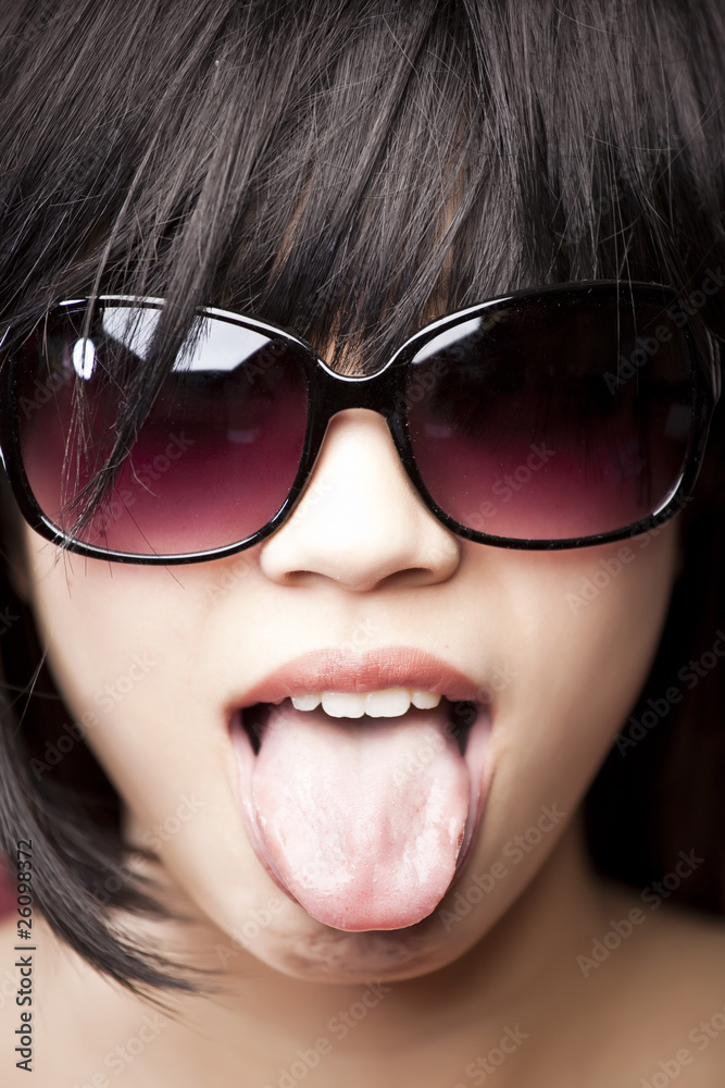 Chinese woman wearing sunglasses and tongue out Chinese woman wearing sunglasses and tongue out