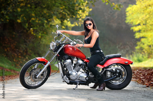 Attractive girl on a motorbike posing outside