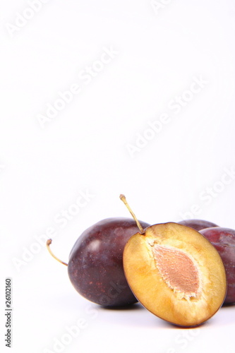 Plums on white background with space for text