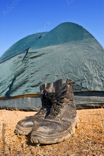 dirty touristic boots near a tent