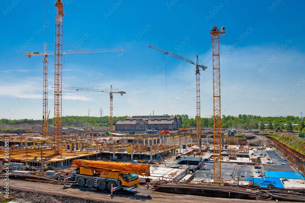 Construcion site with several yellow cranes