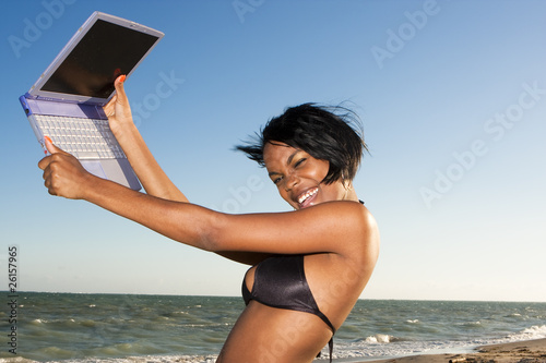 african-american female at the beach on laptop