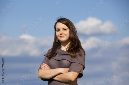 lächelnder weiblicher Teenager posiert mit verschränkten Armen