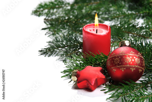 rote Christbaumkugel mit Kerze auf Tannenzweig isoliert auf weiß