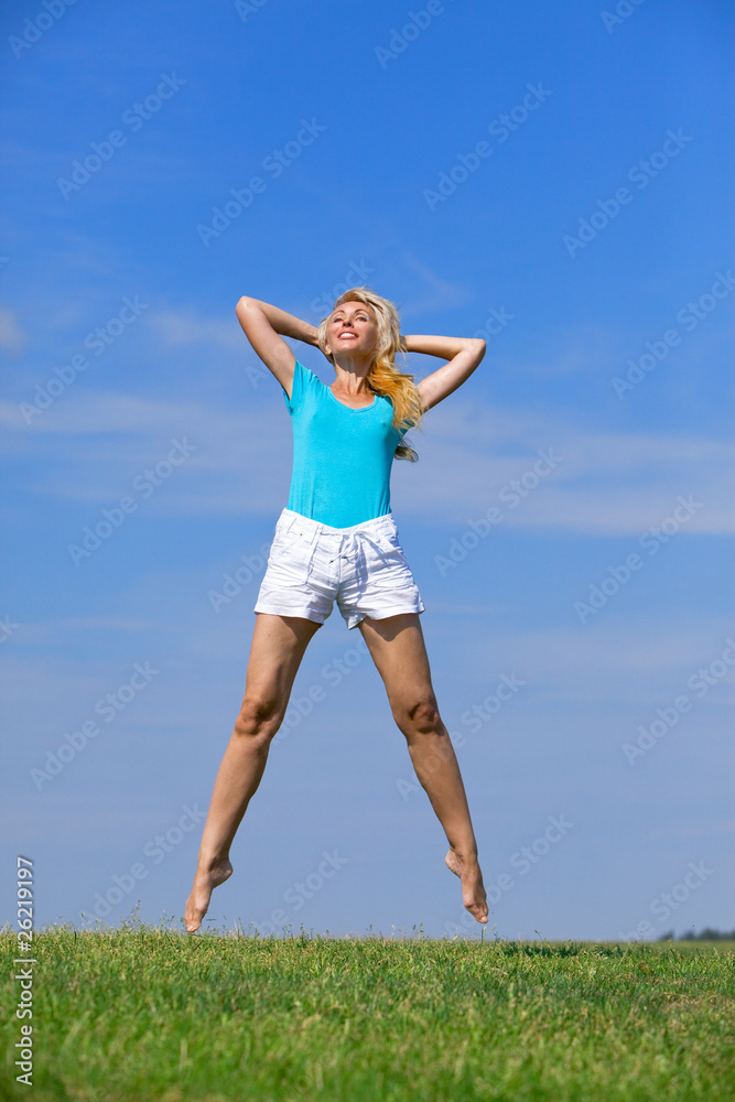 pretty young woman jumping on green grass pretty young woman jumping on green grass