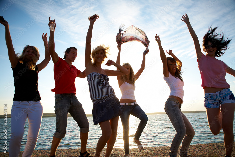 Obraz premium group of happy young people dancing at the beach