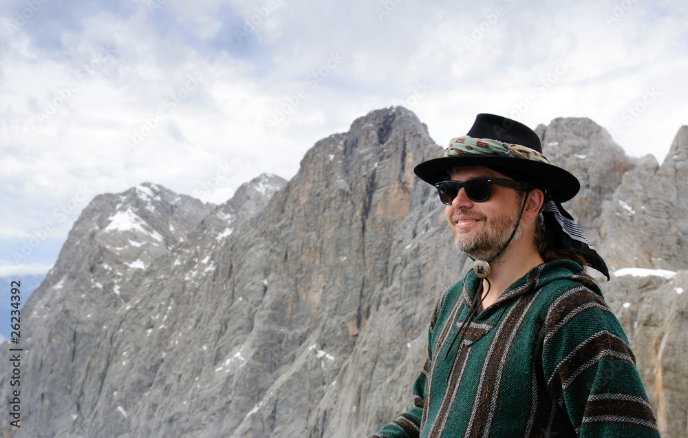 freundlicher Wanderer lächelt vor den Gipfeln des Dachsteinmassi