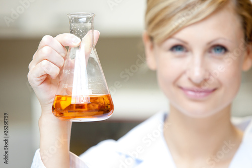 Fotografie Close-up of a female scientist holding an erlenmeyer and smiling