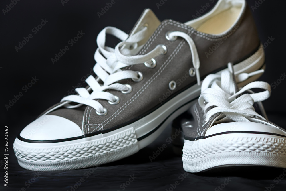gray sneakers classic youth footwear at black background