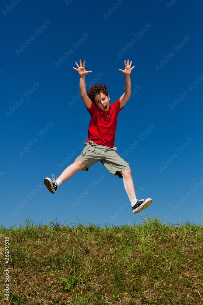 Boy jumping, running against blue sky Boy jumping, running against blue sky