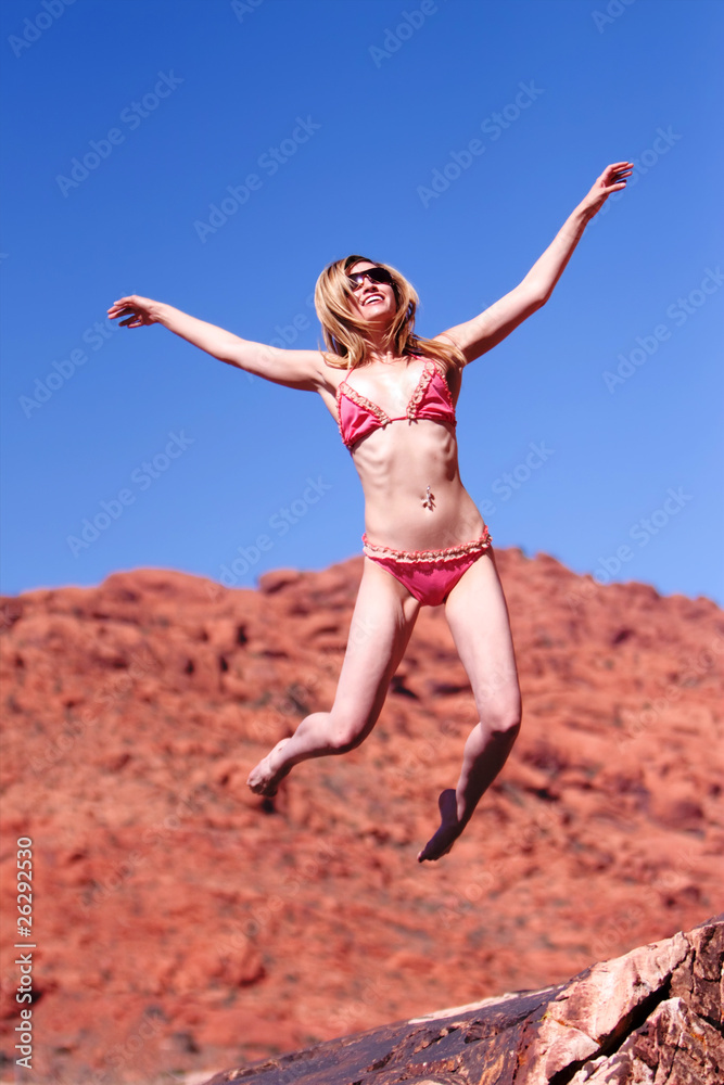 Woman in bikini jumping outdoors Woman in bikini jumping outdoors