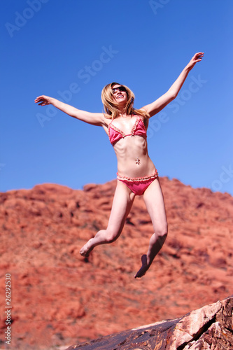 Woman in bikini jumping outdoors
