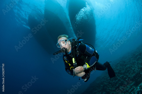 scuba diver and boats in background