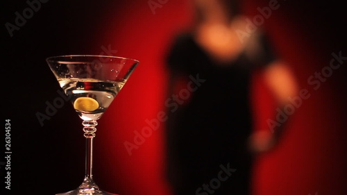 Olive falls in a glass of martini