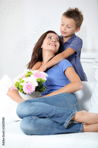 Little boy giving flowers to his mom on mother's day