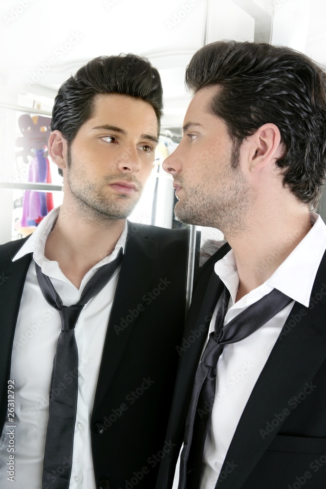 Handsome narcissistic young man looking in a mirror Handsome narcissistic young man looking in a mirror