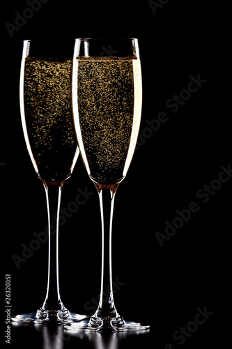 A glass of champagne, isolated on a black background.