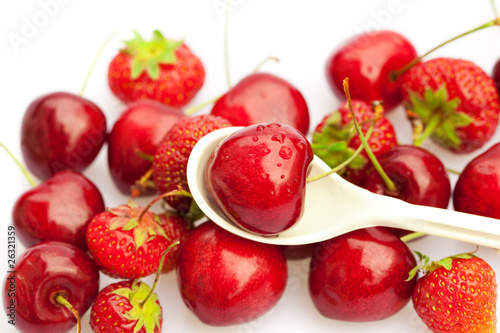 Fototapeta Naklejka Na Ścianę i Meble -  cherry in a spoon against a background of strawberries and cherr