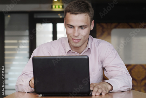 attractive man with a smile work on laptop