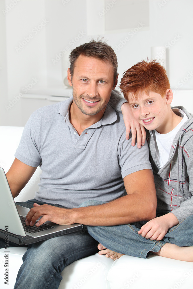 Man and child at home with laptop computer Man and child at home with laptop computer