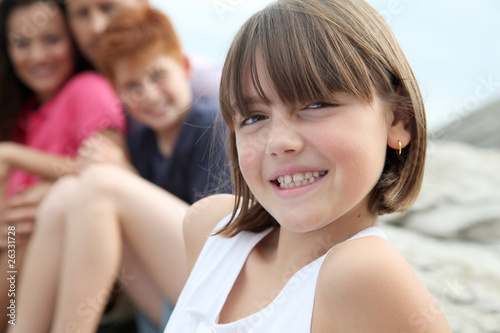 Little girl looking at camera and family in background