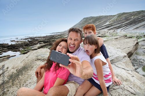 Father taking picture of the family in front of the sea