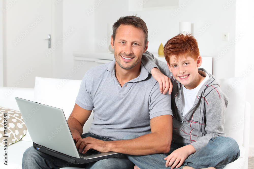 Man and child at home with laptop computer Man and child at home with laptop computer