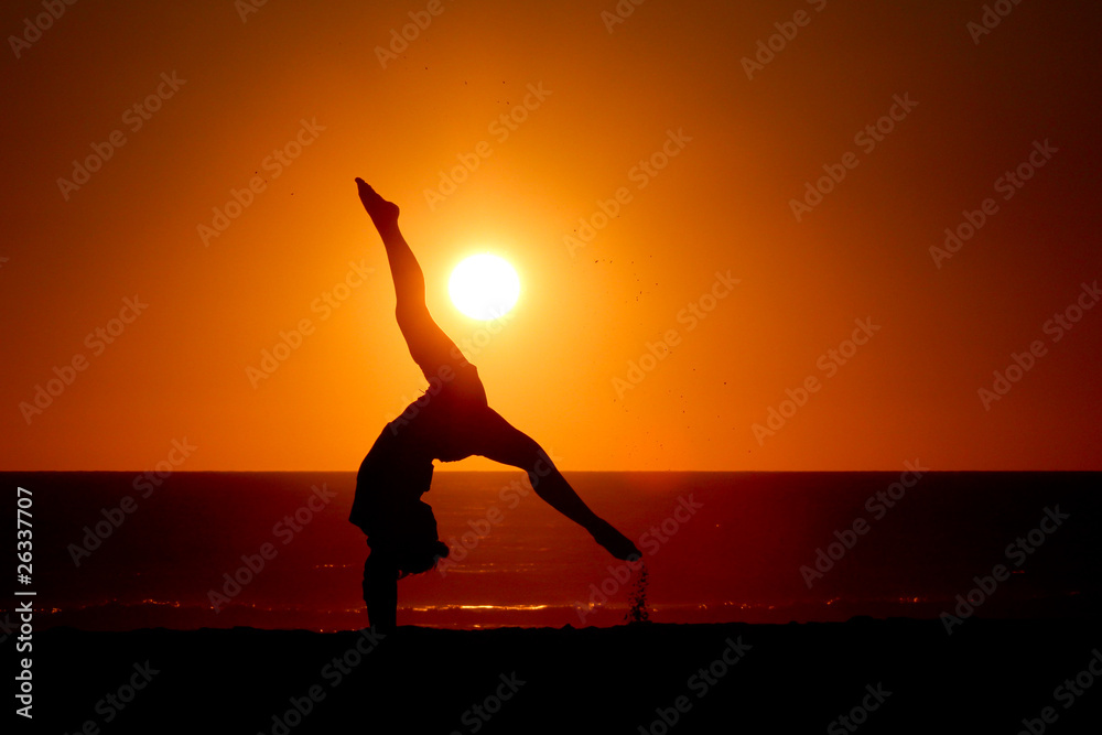 sunset silhouette gymnast on beach