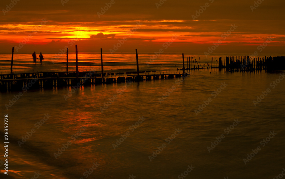 Fototapeta premium Para obserwująca zachód słońca nad morzem