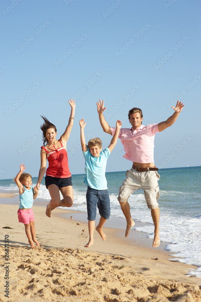 Portrait Of Family On Beach Holiday Jumping In Air Portrait Of Family On Beach Holiday Jumping In Air