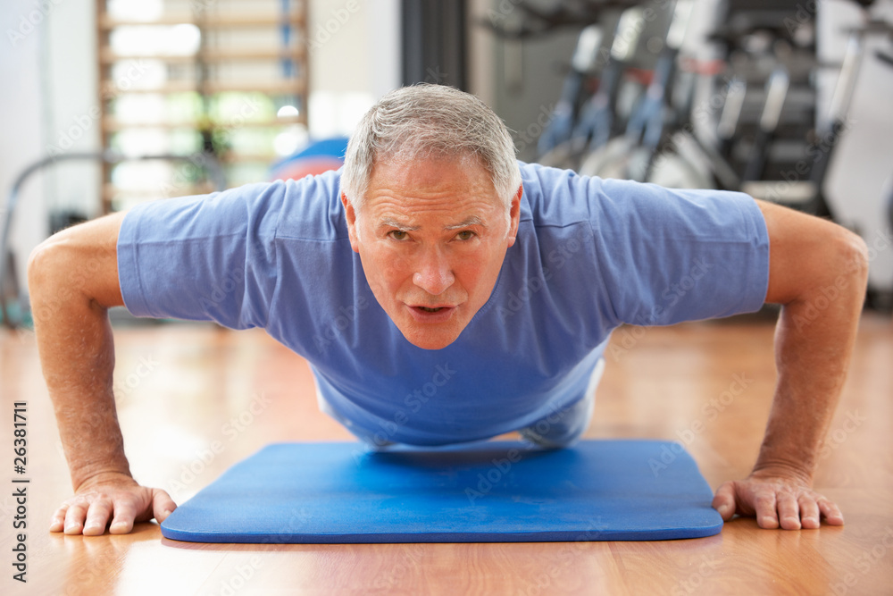 Fototapeta premium Senior Man Doing Press Ups In Gym