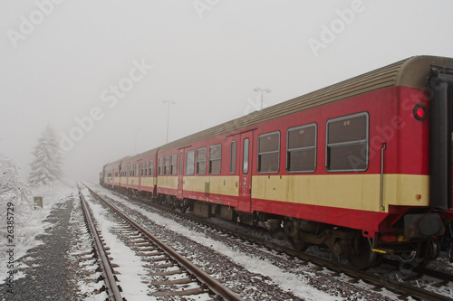 Red train in freezing weather with frozen trees and fog
